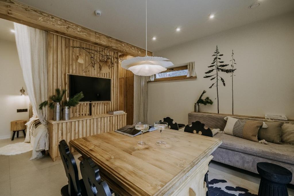 uma sala de estar com uma mesa e um sofá em Zakątek Krupówki - Apartamenty w Centrum em Zakopane