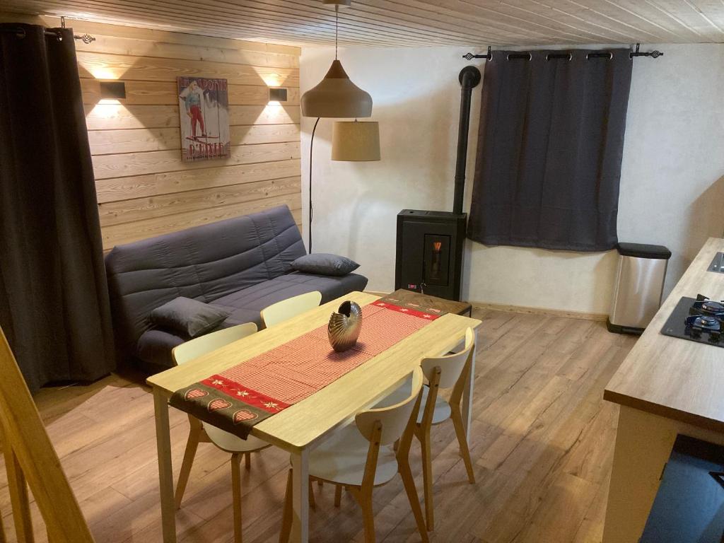ein Wohnzimmer mit einem Tisch und einem Sofa in der Unterkunft Maison Boutxy Le Clos des Ours in Matemale