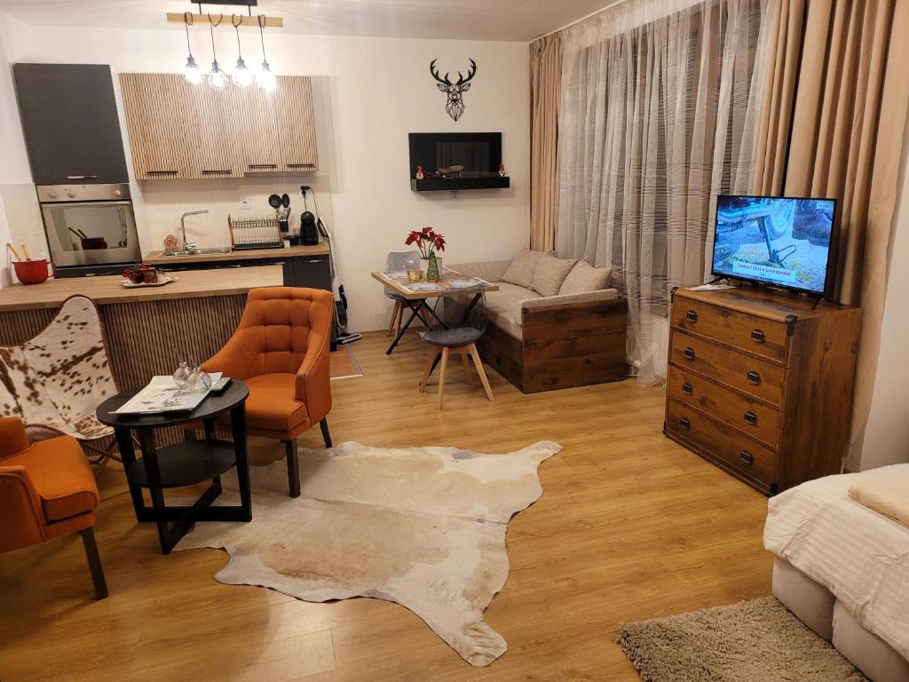 een woonkamer met een bank en een tafel met een tv bij BH and Semiramida Ski Apartment in Borovets