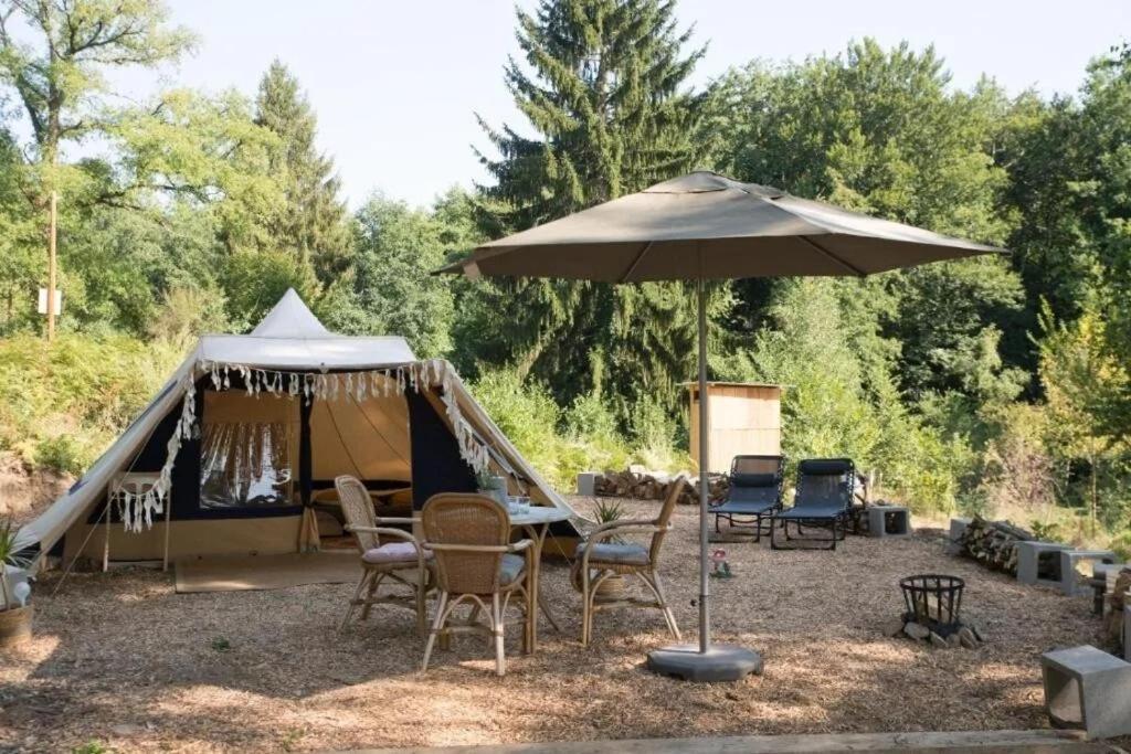 una tenda con sedie, tavolo e ombrellone di Luxe tent Coq de Marans 