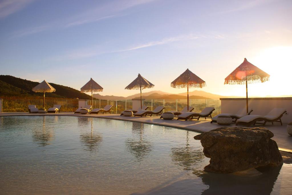 una piscina con sillas y sombrillas en un complejo en Villa Agostina, en Murta Maria