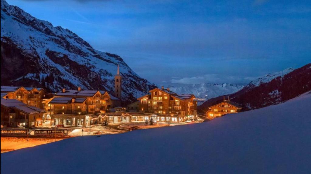 un lodge en las montañas por la noche con nieve en résidence 4 étoiles, en Tignes