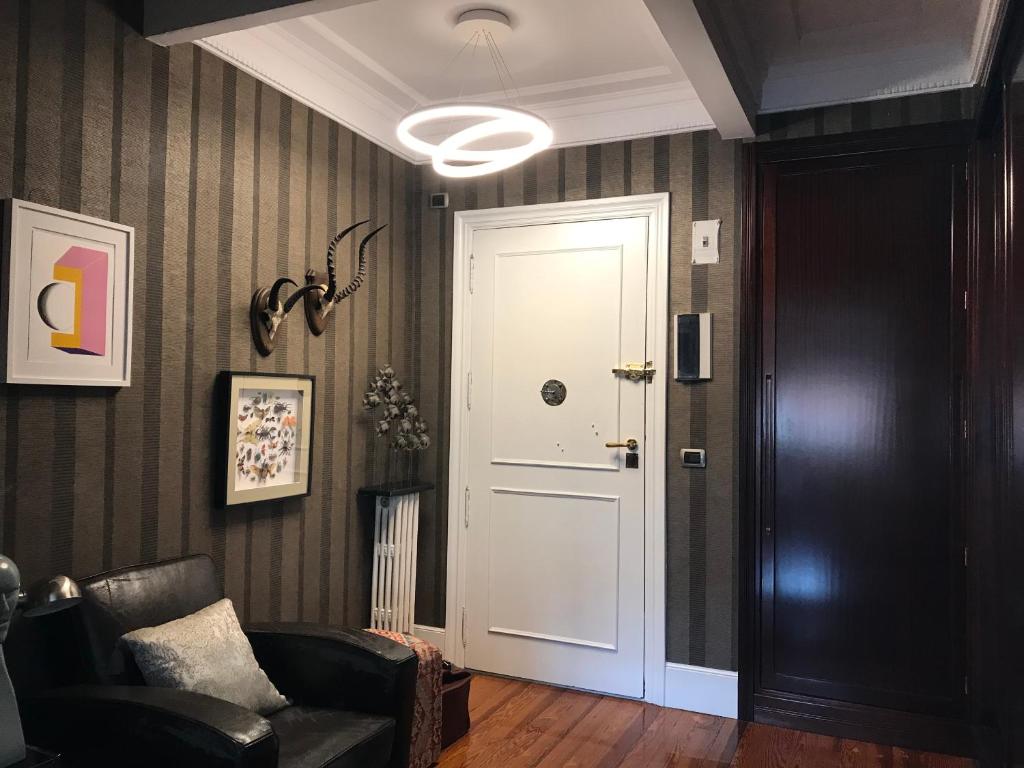 korytarz z białymi drzwiami i krzesłem w obiekcie Habitación grande y confortable con baño privado junto a Guggenheim w mieście Bilbao