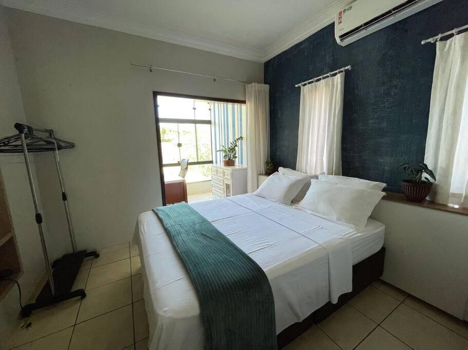 um quarto com uma cama grande e uma parede azul em Casa conforto e estilo em Palmas