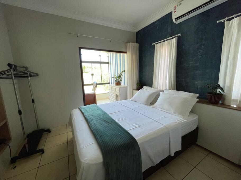 a bedroom with a large bed with a blue wall at Casa conforto e estilo in Palmas