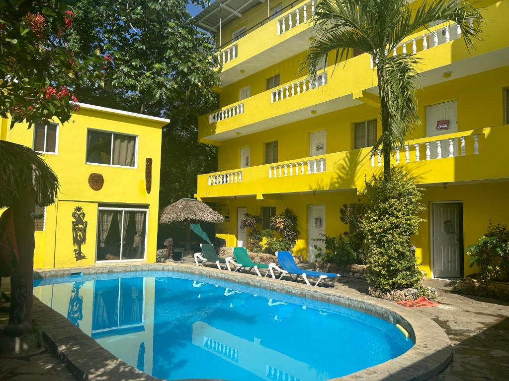 a hotel with a swimming pool in front of a building at Coco Hotel and Hostel in Sosúa