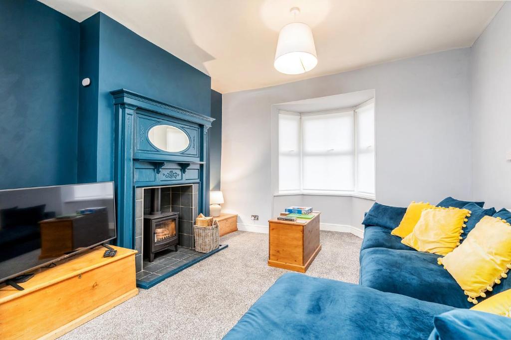 sala de estar con sofá azul y chimenea en The Cleveland Way, North Yorkshire, en Loftus