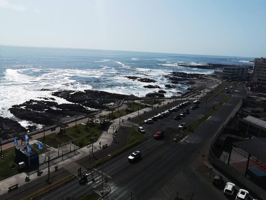 uma vista aérea de uma rua com carros e do oceano em frente a la playa vista preciosa 3 habitaciones 2 baños em Iquique