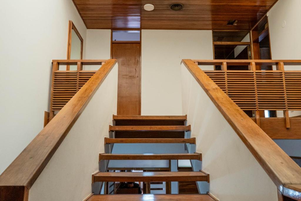 eine Treppe in einem Haus mit Holzgeländer in der Unterkunft Hostel Casa Roble in Mendoza
