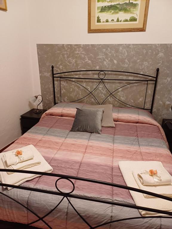łóżko z dwoma białymi ręcznikami na górze w obiekcie Appartamenti Belfiore w mieście Pitigliano
