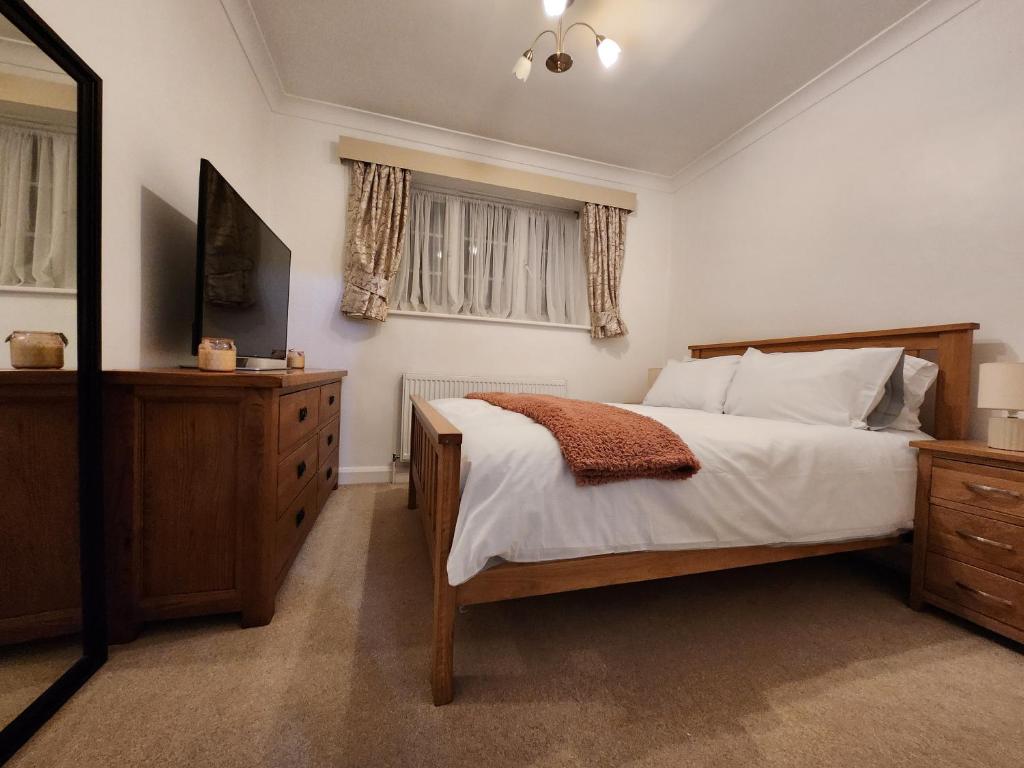 a bedroom with a bed and a dresser and window at Elmdon House with 4 Spacious Bedrooms to choose in Birmingham