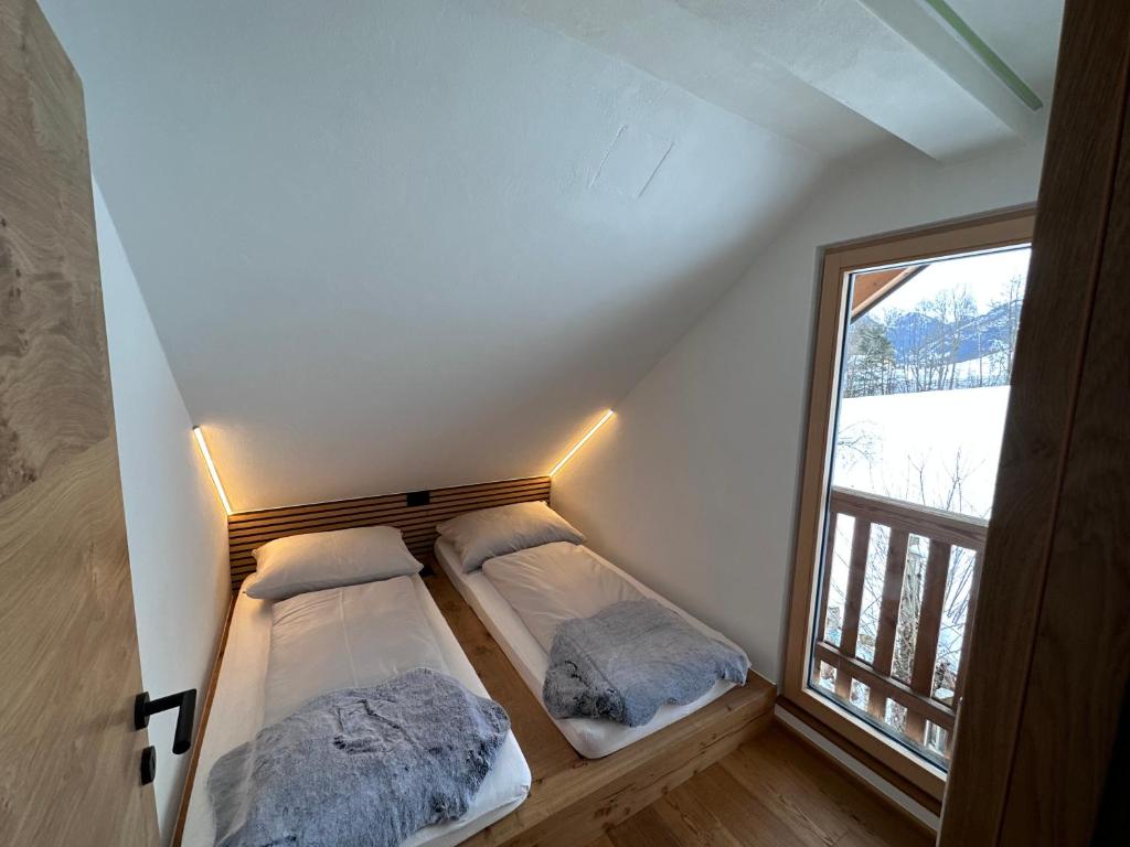 two beds in a room with a large window at DAS MANFRED in Sankt Michael im Lungau
