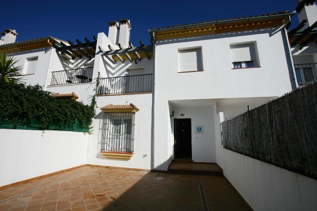 uma casa branca com um portão e um pátio em Casa Rural Rafael Alberti em El Bosque