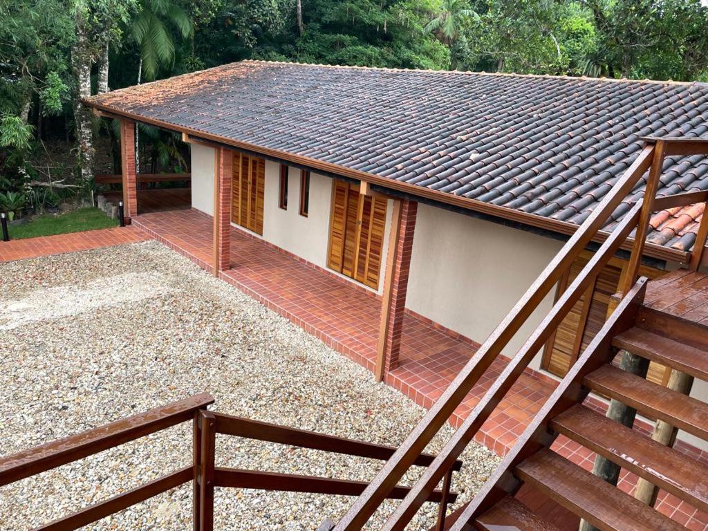 a house with a deck and stairs in front of it at Vila Guaraú in Peruíbe