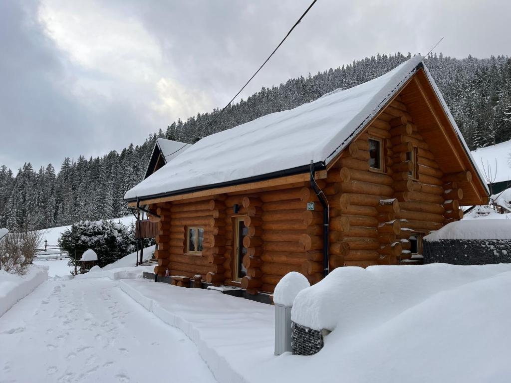 a log cabin with snow on the roof at Zrub Hanesy in Donovaly