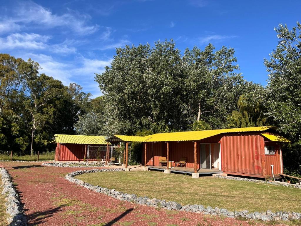 a building with a yellow roof and a yard at Techos Amarillos aparthotel in Fomento