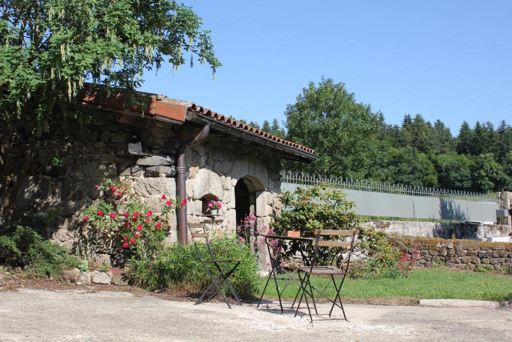 a table and chairs sitting outside of a stone building at Gite Le Cantou in Saint-Maurice-de-Lignon