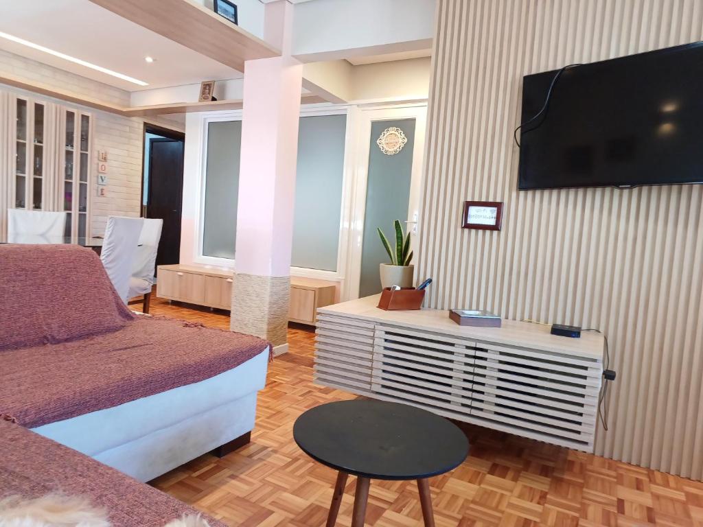 a bedroom with a bed and a tv on a wall at Angi Hosting in Porto Alegre