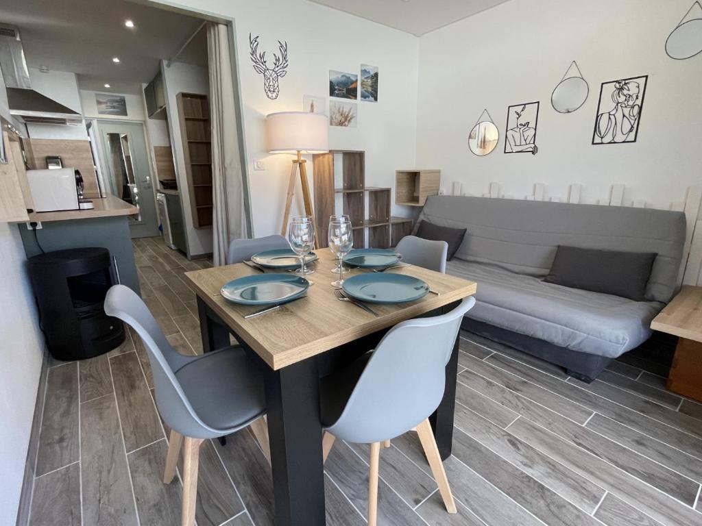 een eetkamer en een woonkamer met een tafel en stoelen bij Moment magique aux pieds des pistes à Superdevoluy in Le Dévoluy