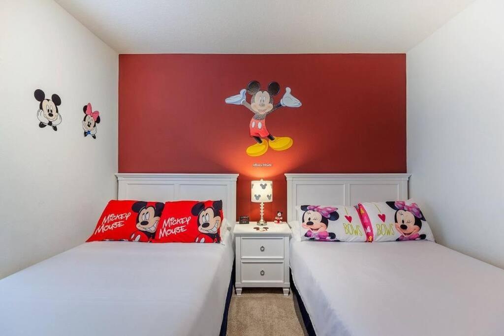 een slaapkamer met 2 bedden en een muur met mickey muis decoraties bij Enjoy a Cozy 3 BR/Clubhouse/Near Disney and more in Kissimmee