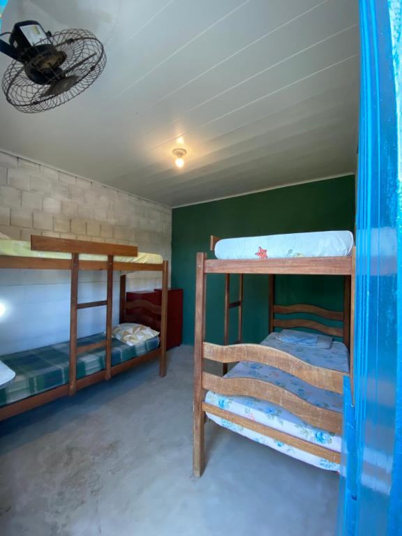 a room with three bunk beds and a ceiling at Natus Hospedagem in Barra de São Miguel