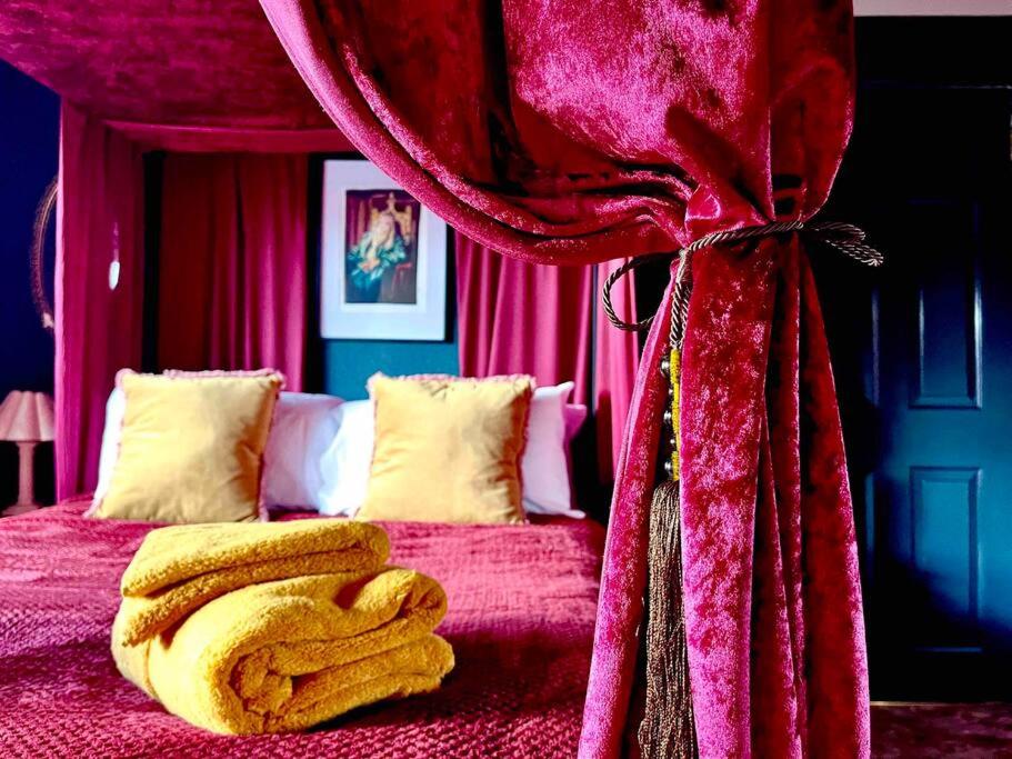 a bedroom with a bed with a red curtain at The Wizards House York - discounts for long stays in York