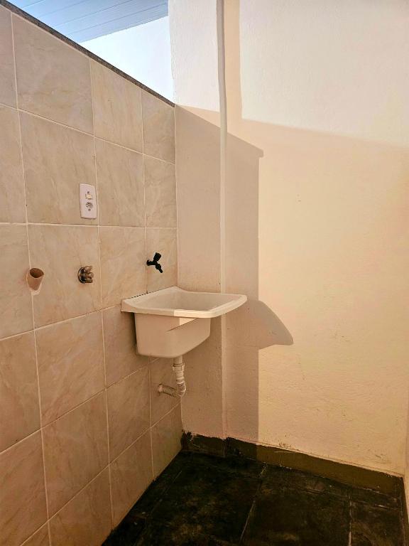 a bathroom with a white sink on the wall at Casa / kitinete in Juiz de Fora