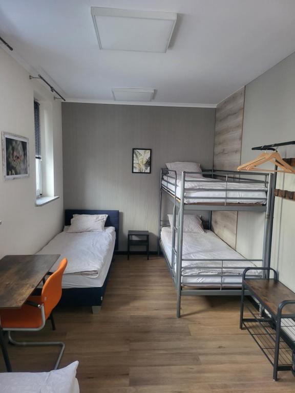 a room with two bunk beds and a table at Rooms4Rest Bokserska - Private rooms for tourists - ATR Consulting Sp, z o,o, in Warsaw