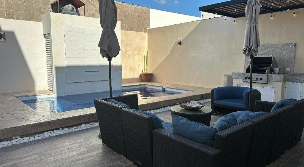 a swimming pool with two chairs and an umbrella at Casa Completa con Alberca privada in La Paz