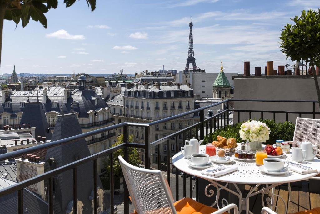 uma mesa numa varanda com vista para a torre Eiffel em Hôtel San Régis em Paris