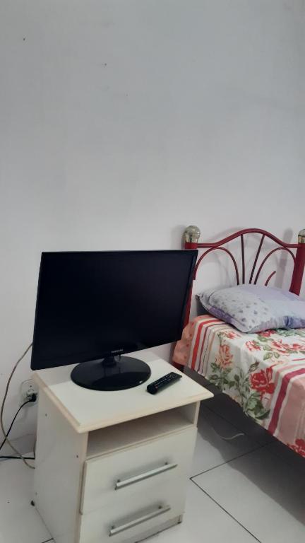 einen TV auf einem Schreibtisch neben einem Bett in der Unterkunft Quarto no Catete in Rio de Janeiro