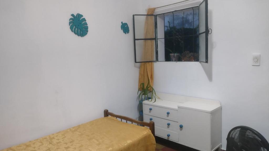 a bedroom with a bed and a window and a dresser at Lo de Gavy in Concepción del Uruguay