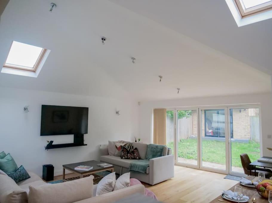 sala de estar con muebles blancos y TV de pantalla plana en Charming Oasis with Garden en Londres
