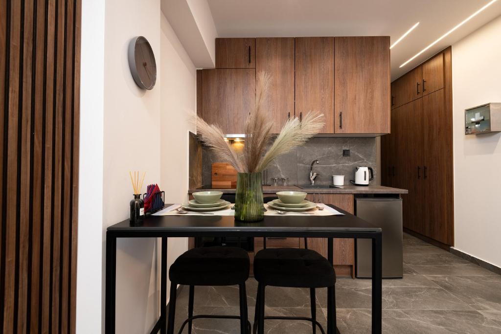 a kitchen with a black table with two chairs at LP Citycenter Suite in Serres