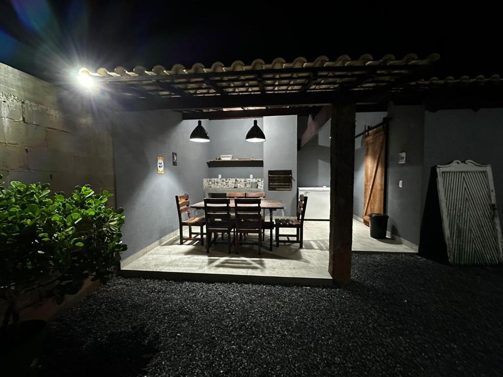 a patio with a table and chairs at night at Rancho Ameixeira in Paty do Alferes