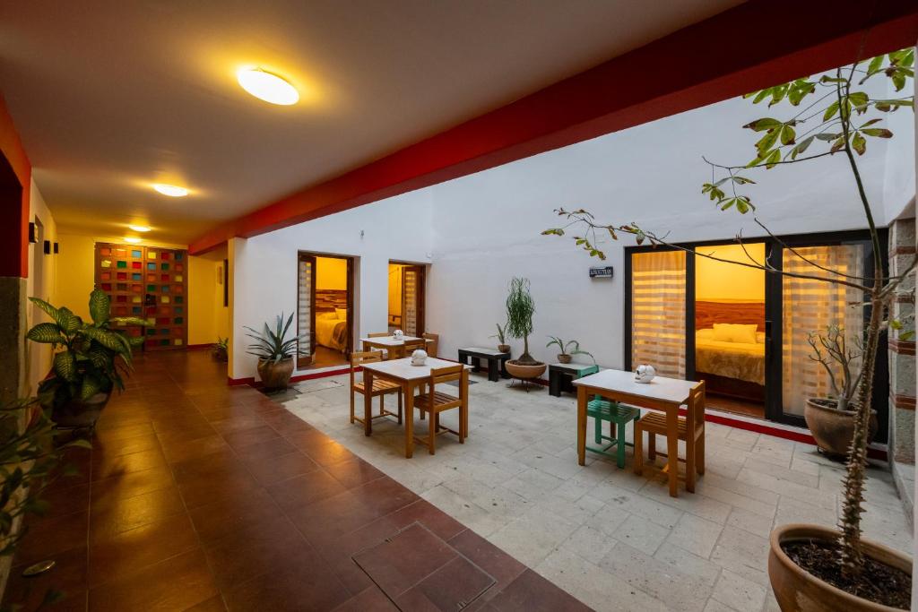 a living room with tables and chairs and plants at CASA FORTALEZA in Oaxaca City