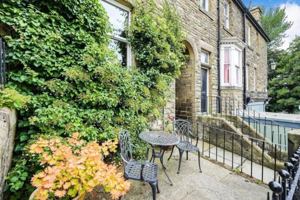 un patio avec des chaises et une table à côté d'un bâtiment dans l'établissement Homely 4 bed cottage central characterful, à Pateley Bridge