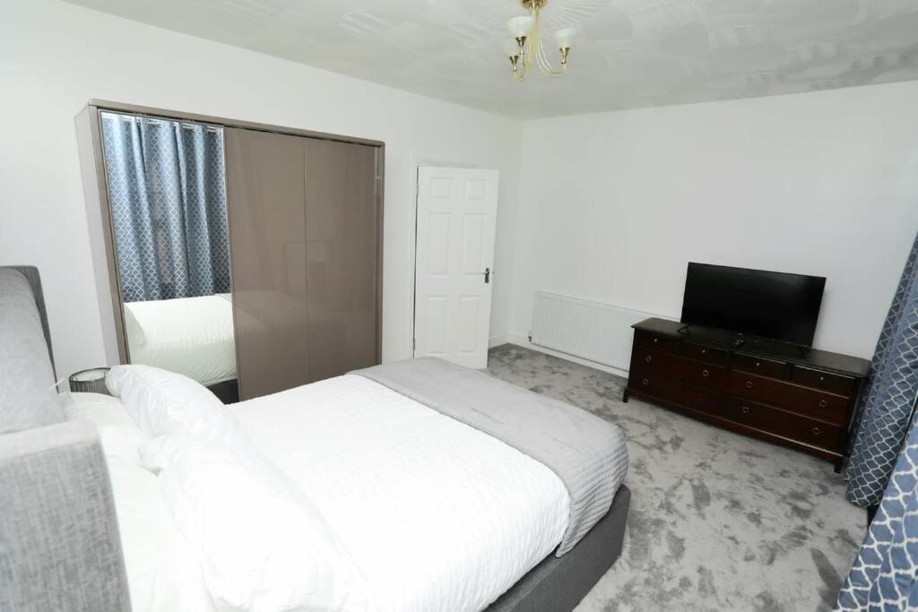 a bedroom with a white bed and a television at Impeccable 3 bedroom house in Plumstead