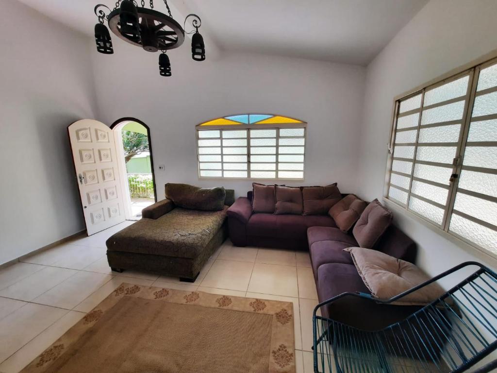 uma sala de estar com um sofá roxo e uma cadeira em linda chácara com casa principal pomar & piscina em Serra Negra