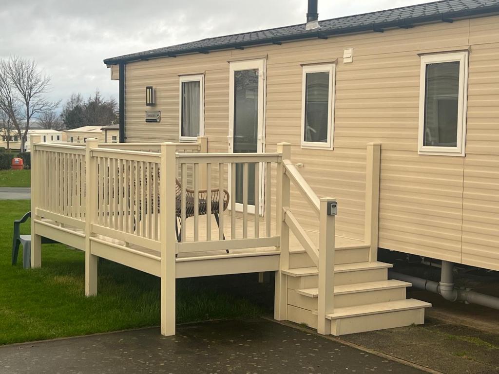 a house with a deck with a dog sitting on it at Seton Sands Muirfield 6 in Port Seton