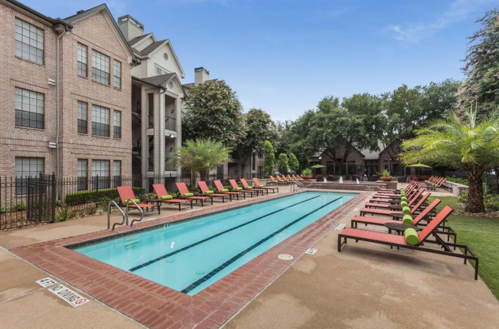 a swimming pool with lounge chairs and a building at Amazing Houston Apartment with Pool+ Fast Internet in Houston