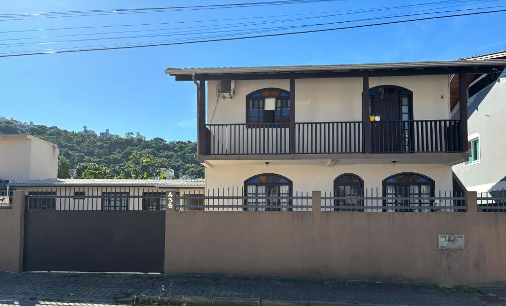 a building with a balcony and a fence at Casas Verão Bombinhas in Bombinhas