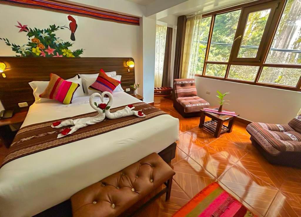 um quarto com uma cama grande e toalhas em Machupicchu Adventure Hotel em Machu Picchu