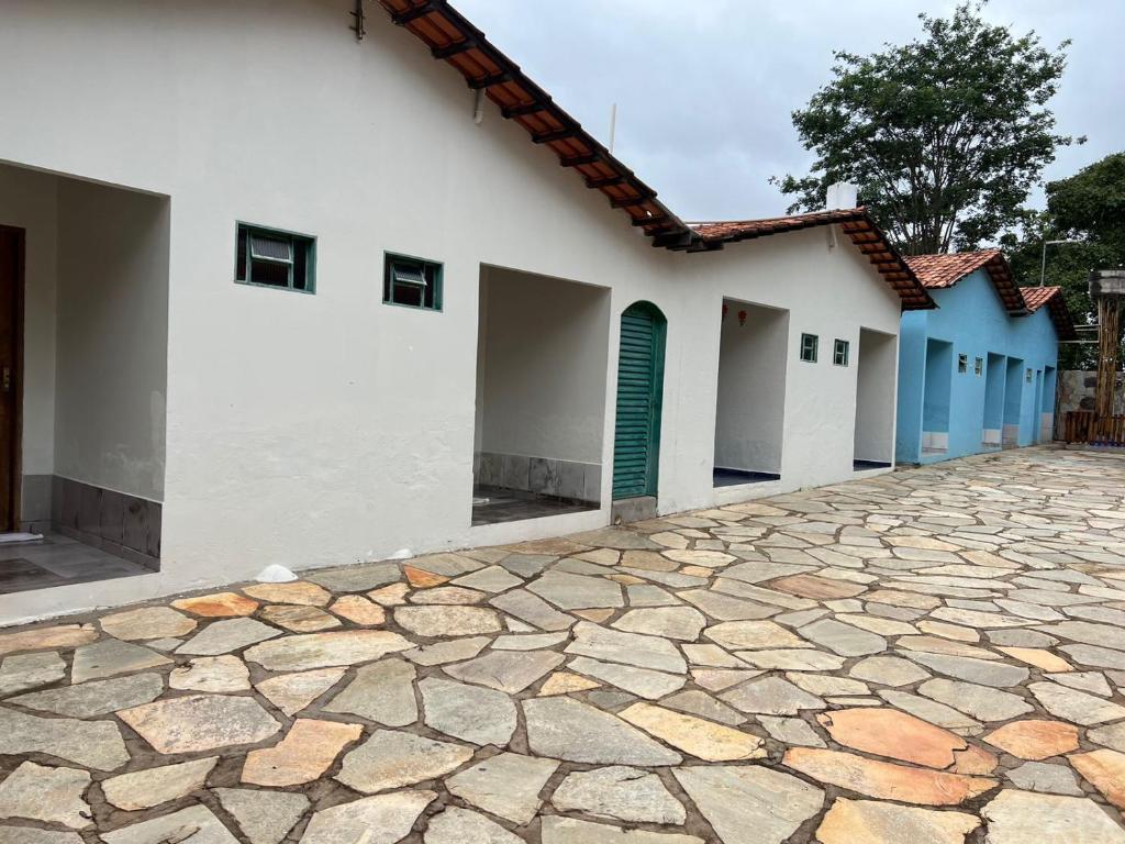 a row of houses with blue doors and a stone driveway at Casadabiquinha in Pirenópolis