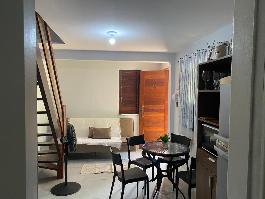 a small kitchen with a table and chairs in a room at Apartamentos Aconchegantes, Villa da Praia in Praia do Forte