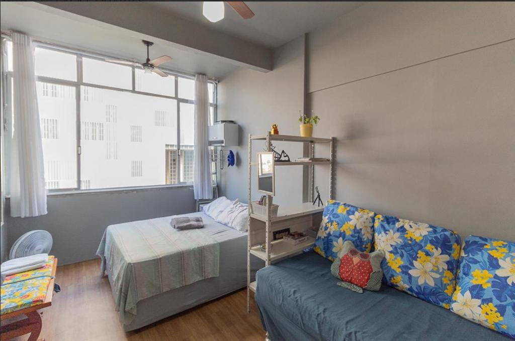 a living room with a couch and a bed at Studio no Largo da Carioca - Rio de Janeiro in Rio de Janeiro