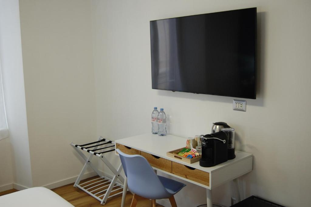 a desk with two chairs and a television on a wall at Belltower Elegans in Rome