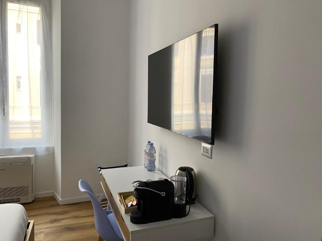a room with a table and a tv on a wall at Belltower Elegans in Rome