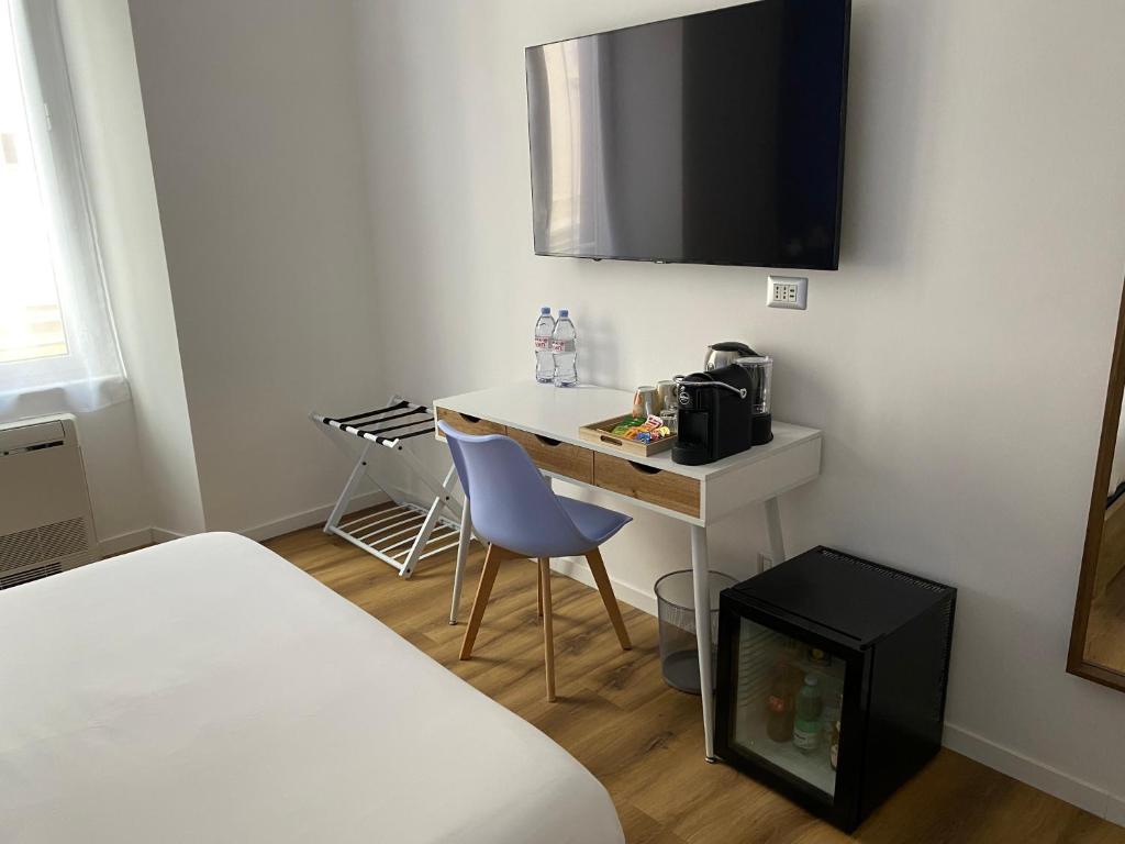 a small room with a desk with a microwave and a bed at Belltower Elegans in Rome