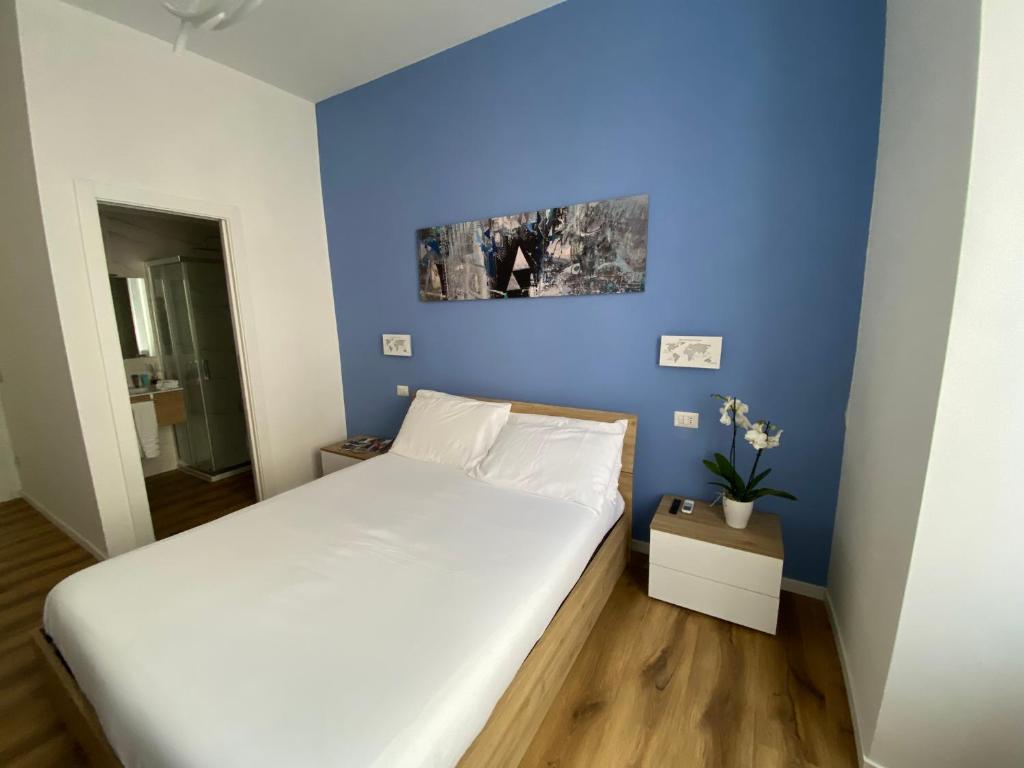 a bedroom with a large bed with a blue wall at Belltower Elegans in Rome